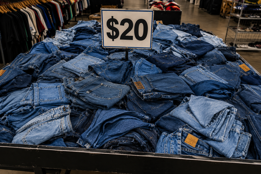 Stack of blue jeans with a $20 sign in a store setting